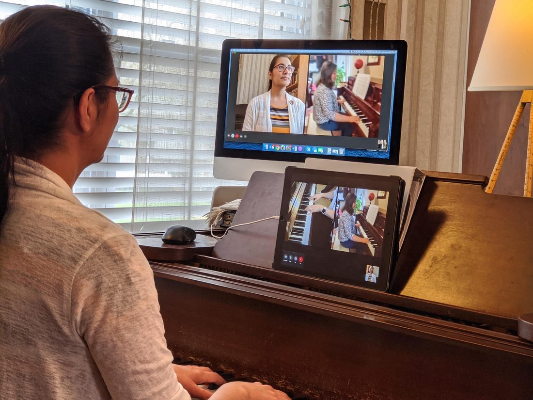 A live, remote piano lesson shown on a screen.