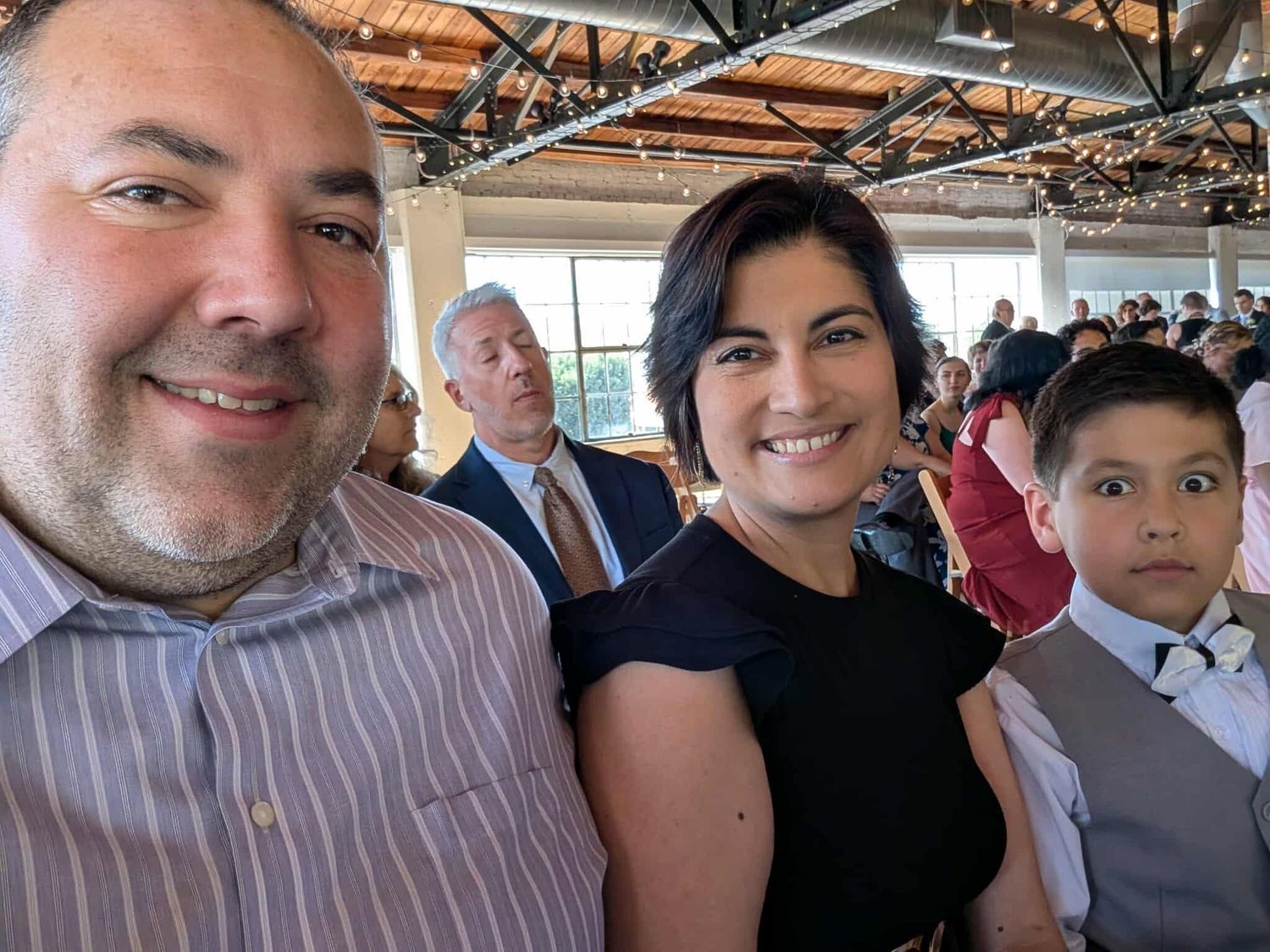 The founder's family dressed up at a wedding with string lights.